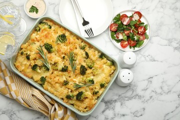 Tasty pasta casserole with cheese and broccoli served on white marble table, flat lay. Space for text