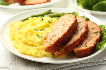 Delicious baked turkey meatloaf with mashed potato served on table, closeup