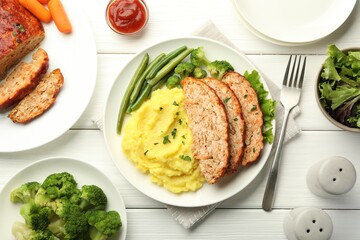 Delicious baked turkey meatloaf with mashed potato served on white wooden table, flat lay