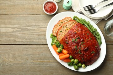 Delicious baked turkey meatloaf with vegetables served on wooden table, flat lay. Space for text