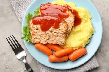 Delicious baked turkey meatloaf with mashed potato served on grey table, top view