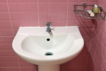 Porcelain sink in bathroom with shelf on wall