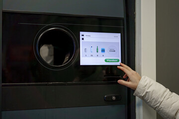 A woman receives a receipt from a vending machine that accepts plastic and aluminum drink bottles.