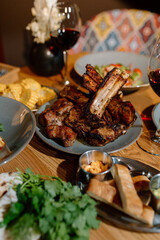 Yummy eastern cuisine served in the restaurant. Georgian food. Eastern food. Grilled lamb meat, salad, grilled corn, appetizers, red wine