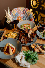 Yummy eastern cuisine served in the restaurant. Georgian food. Eastern food. Grilled lamb meat, salad, grilled corn, appetizers, red wine