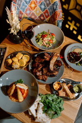 Yummy eastern cuisine served in the restaurant. Georgian food. Eastern food. Grilled lamb meat, salad, grilled corn, appetizers, red wine