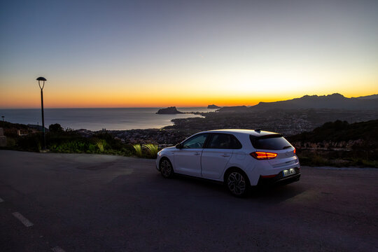 Hyundai i30 along a quiet road by the Spanish coast at sunset, Image shows the white i30 in the final moments of sunlight on a hill overlooking Moraira