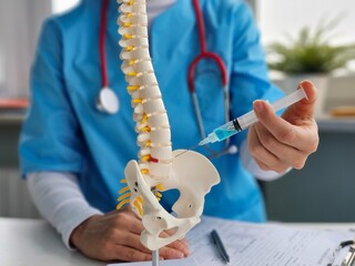 Injection from a syringe with an anesthetic drug into an intervertebral disc herniation,