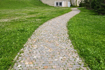 Fragment of a stone path among the grass