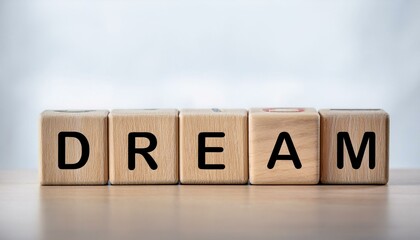 夢を意味する英単語のDREAMの文字が書かれた木製のキューブブロックが横に並んでいる。aiで生成	