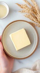 Fresh Creamy Butter Block on Elegant Plate Surrounded by Natural Decor and Soft Tones for Culinary and Food Photography Inspiration