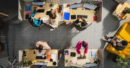Top Down View of Diverse Team in a Corporate Office: Colleagues Using Desktop Computers To Analyze Financial Data, Write Reports, Calculating Sales Growth And Revenue. Technological Startup Concept