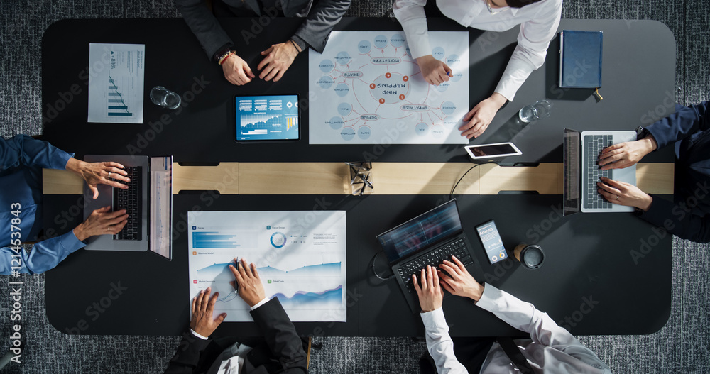 Fototapete Diverse Professionals Working on Business Statistics Reports and Digital Plans in an Office. Top Down View of Discussion and Data Analysis on Laptops and Charts. Teamwork and Innovation Concept