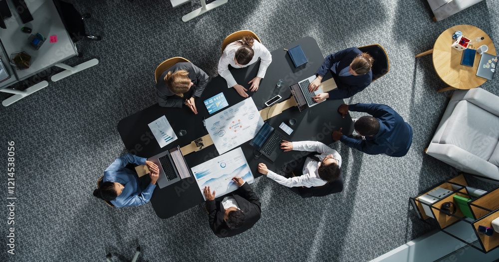 Fototapete Diverse Professionals Working on Business Statistics Reports and Digital Plans in an Office. Top Down View of Discussion and Data Analysis on Laptops and Charts. Teamwork and Innovation Concept
