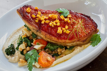 pan roasted pork chop served with seasonal vegetables