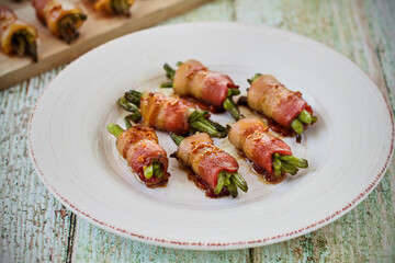 bacon wrapped green beans served on a plate and a cutting board