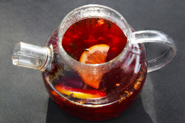 Hot black tea with cinnamon and lemon, brewed in a glass teapot