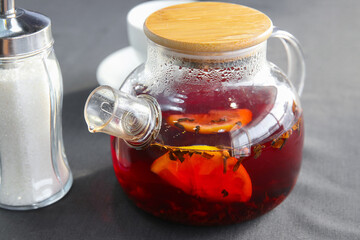 Hot black tea with cinnamon and lemon, brewed in a glass teapot
