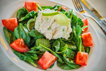 chicken salad on a bed of mixed greens with tomatoes