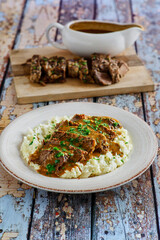 sliced pot roast on a bed of mashed potatoes