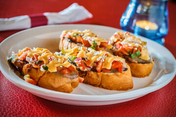Mexican crostini refried beans, pico de gallo, and toasted cheese