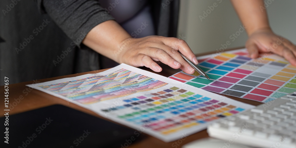 Poster focused graphic designer selecting color swatches and working on design concepts in a modern office 