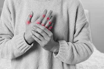 Woman with joint inflammation indoors, closeup. Toned in black-and-white with color areas on fingers