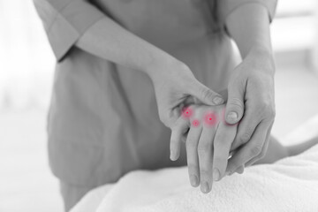 Woman with joint inflammation receiving hand massage in wellness center, closeup. Black-and-white