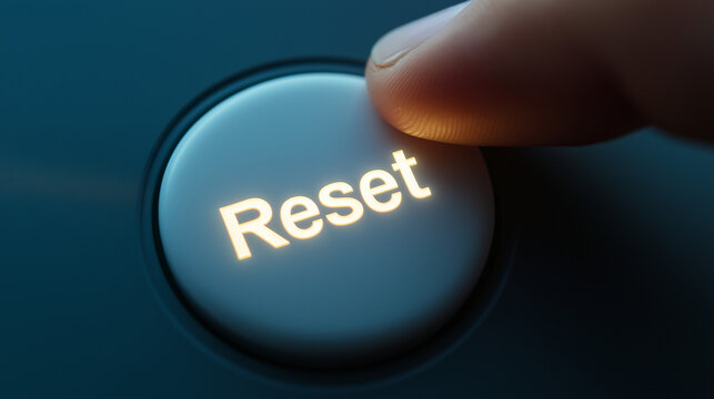 White "Reset" button on dark surface. Perfect for system restart and refresh concepts.