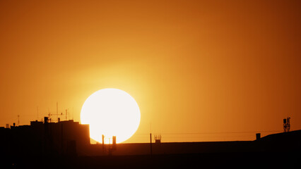 Big sun and a view of the rooftops of the city