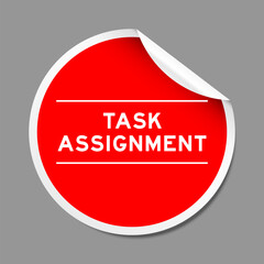 Red color peel sticker label with word task assignment on gray background