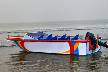 This picture is of the Mandarmani coast in the Bay of Bengal near Digha, India, where an empty fiberglass single-hull boat floats on the billow waves.
