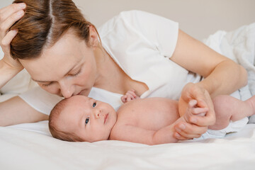 Mother and baby. Loving mom spending time with her little two week old child at home.