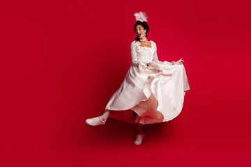 Photo of excited lady countess duchess dancing moving wearing antique dress isolated red color...