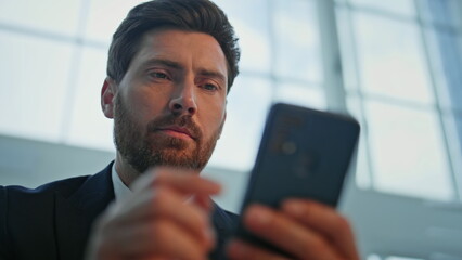 Serious executive browsing smartphone reading work email closeup. Portrait man