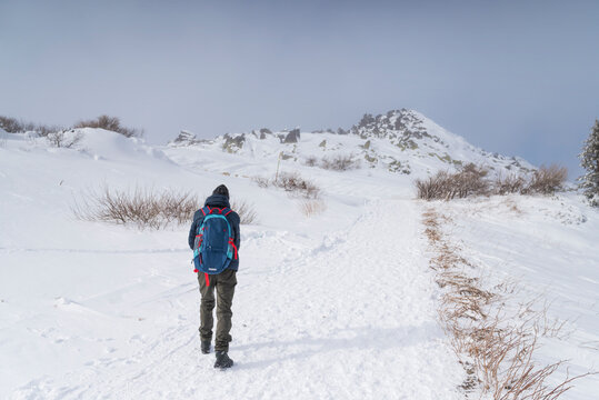 Senior man hiking  in the winter snowy mountain 