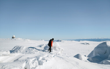 Hiker woman hiking in the high winter snowy mountain with stunning view 