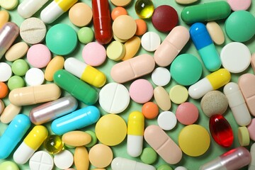Various pills on green background