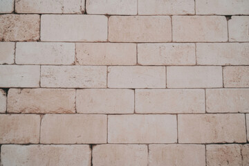 Fototapeta premium A brick wall with a rough texture and a light color