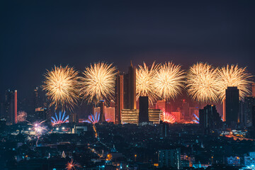 New year festival with firework display glowing over department store, illuminated building in downtown