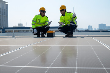 Young engineer in uniform sits on a solar farm, clean energy