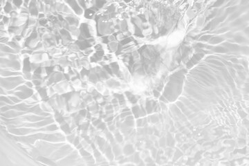 White water with ripples on the surface. Defocus blurred transparent white colored clear calm water surface texture with splashes and bubbles. Water waves with shining pattern texture background.