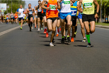 dozens runners sprint down wide city road during  competitive race.