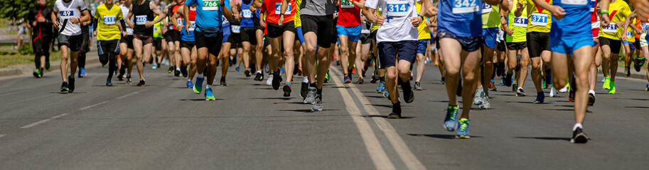 large group runners races down wide city street during marathon