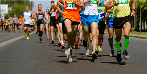 group athletes is racing down city street during marathon