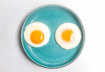 a plate of fried eggs on a white background