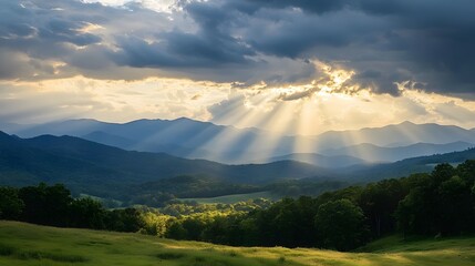 Dramatic mountain landscape with sun rays breaking through clouds, vibrant greenery in the foreground, perfect for nature themes.