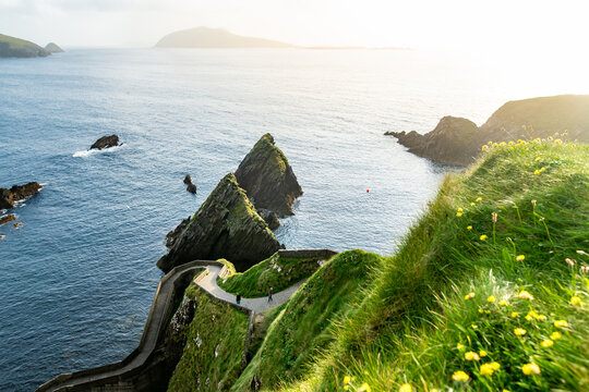 Dunquin or Dun Chaoin pier, Ireland's Sheep Highway. Narrow pathway winding down to the pier, ocean coastline, cliffs. Popular location on Slea Head Drive and Wild Atlantic Way.