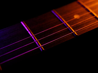 Electric guitar strings close up. Musical instrument details. Concert color contrast lighting. Six-string guitar during performance. Bright colors on dark background. Cinematic light. Copy space