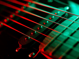 Electric guitar strings close up. Musical instrument details. Concert color contrast lighting. Six-string guitar during performance. Bright colors on dark background. Cinematic light. Copy space